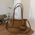 Braune Schultertasche mit Nieten und Mini-Tasche auf einem hölzernen Tisch - Braun