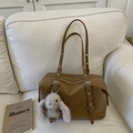 Borsa tote vintage in pelle marrone con ciondolo a coniglio su divano bianco - Con Ciondolo / Marrone