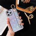 Detail of glitter iPhone case featuring gold bee charms and a pearl wrist strap handle - White (Plaid Bee Wristband) / iPhone 7/8/SE 2020