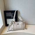 Schicke beige Kordelzug-Tasche aus Leder mit Litschi-Muster und stilvollen Metallteilen - Gebrochenes Weiß