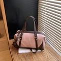 Bolso Boston de lona rosa con adornos de cuero marrón y luz natural en una mesa de madera - Rosa