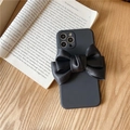 Matte black iPhone case with a large leather bow on a vintage book backdrop - Black / iPhone 13 Pro