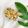 Soporte de teléfono dorado con textura arrugada sobre seda blanca y hoja verde - Soporte Plisado Retro-Dorado