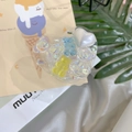 Heart-shaped Griptok with colorful resin bears and pearl accent on a soft white silk background - Epoxy Stand - Heart Laser Candy Bear - Blue Yellow