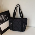 Black quilted tote bag with diamond pattern and side zipper pocket detail - Black
