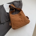 Close-up of deep brown faux suede tote bag with front pockets and matte texture details - Brown