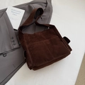 Detailed view of brown faux suede tote bag with front pockets on grey blazer - Brown