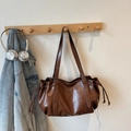 Borsa tote marrone in pelle PU con rivetti in metallo appesa a un gancio in legno - Marrone