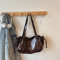 Dettaglio della borsa a tracolla vintage in pelle PU marrone con coulisse e fibbie - caffè