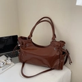 Dark brown glossy tote bag with drawstring detail and silver hardware in office setting - Brown