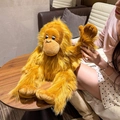 Ginger long-haired orangutan plush doll backpack shown on a wooden table setup - One Size / Brown