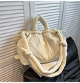 Detail of cream quilted tote bag with drawstring closure and soft padded shoulder strap - White