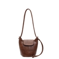 Retro dark brown leather bucket bag with top flap and knotted strap on white background - Brown