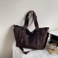 Dettaglio della borsa tote in tela marrone con rivetti in metallo e tasche laterali capienti - Marrone