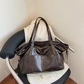 Retro donkerbruine grote tote bag met verstelbare riemen op een zwarte stoel - Bruin