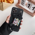 Detailopname van zwarte siliconen hoesje met lintstrik en bloemvormig edelsteen ornament - Zwart (Roze Strass) / iPhone 13PRO