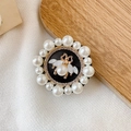 Detail of round pearl-trimmed phone grip with vintage gold bee and center pearl accent - Small Pearl Bee / Black