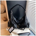 Close-up of black glossy hobo bag with thick metal chain and pleated texture detail - Black