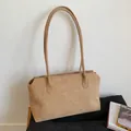 Detalle de bolso tote de ante camel mostrando textura mate suave y correas de hombro - Caqui