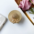 Gouden strohoed telefoonhouder met elegante strik op een luxe witte achtergrond - Gouden Strohoed Met Strik Stijl / Goud