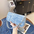 Borsa a cuscino intrecciata blu con catena floreale e tracolla regolabile in mano - Blu