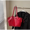 Detalle de bolso tote de charol rojo con lazo decorativo y diseño de cordón lateral ajustable - Rojo