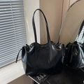 Borsa tote nera lucida con chiusura a coulisse e fiocco con luce naturale della finestra - Nero