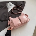 Gros plan du sac à main en cuir verni rose brillant avec deux poches avant zippées - Rose