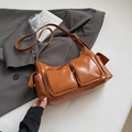 Détail d'un sac à bandoulière en cuir verni marron avec plusieurs poches extérieures - Marron