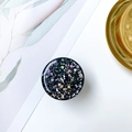 Dettaglio di un supporto circolare per telefono con glitter olografici a forma di stelle e lune - Supporto Cielo Stellato - Nero