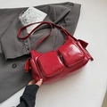 Detail of dark red glossy leather shoulder bag with multi-pocket design and wide strap - Red
