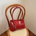 Bolso de hombro rojo brillante con amuleto de corazón sobre silla vintage - Rojo