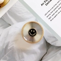Macro shot of gold phone grip with concentric texture and black enamel smiley face - No.16 Smiley - Silver