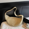 Sac bandoulière croissant en toile beige avec surpiqûres dans un décor lifestyle - Kaki