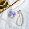 Detailed macro view of clear AirPods case with purple bow and pearl lanyard handle - Purple / AirPods 1/2