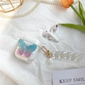 Detalle de funda AirPods con mariposa 3D azul, cadena de perlas y colgante de concha - AirPods 1/2 / Mariposa Irisada-Con Cadena de Concha