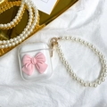 Detailed view of clear TPU AirPods case with a 3D pink bow and white pearl lanyard strap - Pink / AirPods 1/2