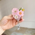 Dettaglio del porta badge a cuore in resina con vere margherite rosa essiccate - Margherita Rosa Accenti Gialli (2)