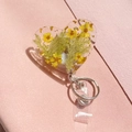 Macro detail of heart-shaped resin badge reel with real yellow dried flowers and gold foil - Yellow Dried Flower Style (1)