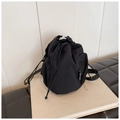 Detalle del bolso tipo saco de nailon negro con cordón, bolsillo de malla y etiqueta lateral - Negro