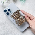 Dettaglio del supporto per telefono a forma di orso in oro con strass su iPhone - Oro Antico