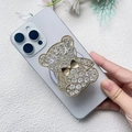 Dettaglio del supporto per telefono a forma di orsetto con strass su smartphone azzurro - Oro