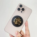 Dettaglio macro del supporto telefono MagSafe con accenti in foglia d'oro e resina - Supporto Magnetico / Foglia d'oro chiaro (Base nera)