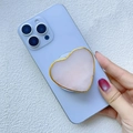 Detail eines rosa Naturstein-Herz-Handyhalters mit eleganter Vergoldung auf blauem Handy - Magnetischer Ständer / Herzförmiger Rosa Achat (Zufälliges Farbmuster)