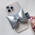 Dettaglio macro del supporto per telefono a fiocco argento con trama metallica ed etichetta - Supporto Magnetico / Fiocco in Pelle Argento