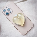 Dettaglio di un supporto Griptok a forma di cuore perlato su uno smartphone colorato - Supporto Magnetico / Giallo Perlato