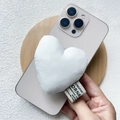 Gros plan d'un support de téléphone en peluche blanche en forme de cœur doux - Support Magnétique / Cœur en Coton Blanc