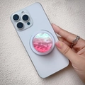 Soporte magnético circular rosa perlado para móvil fijado en un smartphone blanco - Soporte Magnético / Concha Degradada Roja