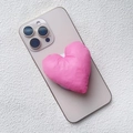 Detail view of a 3D pink heart-shaped padded fabric magnetic phone stand on a gold smartphone - Magnetic Stand / Pink Fabric Heart