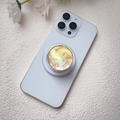 Macro shot of shell texture phone grip with gold trim and retractable stand on white phone - Magnetic Stand / Yellow Gradient Shell With Gold Edge